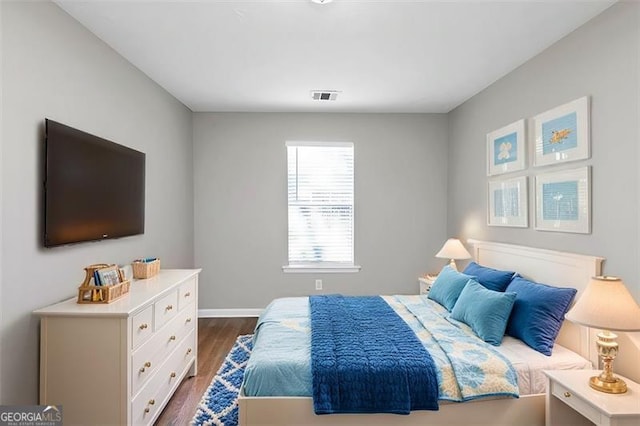 bedroom with dark wood-type flooring