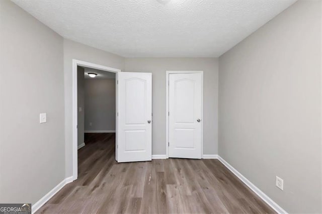 unfurnished bedroom featuring a textured ceiling and light wood-type flooring