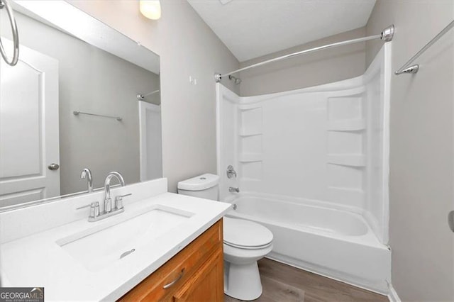 full bathroom with hardwood / wood-style flooring, vanity, toilet, and shower / bath combination