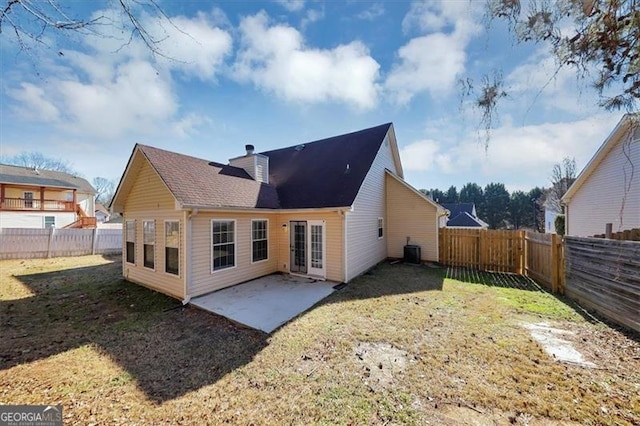 rear view of property with cooling unit, a yard, and a patio