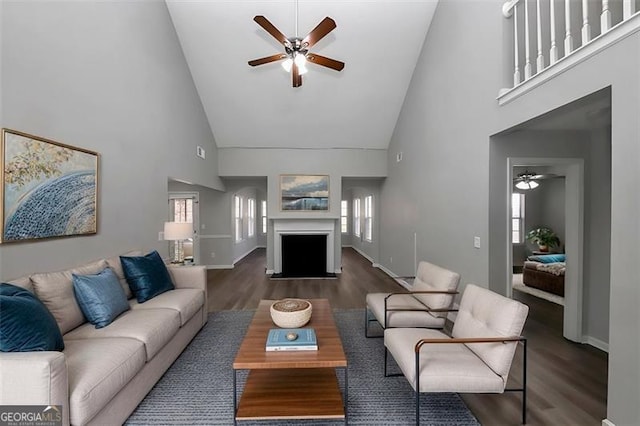 living room with dark hardwood / wood-style flooring, high vaulted ceiling, and plenty of natural light