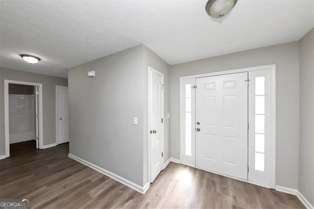 foyer entrance featuring hardwood / wood-style floors and a textured ceiling