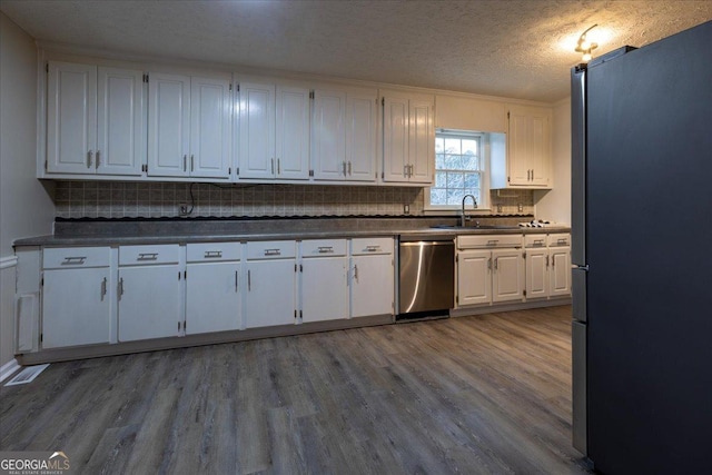 kitchen featuring hardwood / wood-style flooring, white cabinetry, appliances with stainless steel finishes, and sink