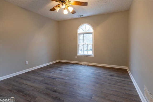 empty room with ceiling fan, dark hardwood / wood-style flooring, and a textured ceiling