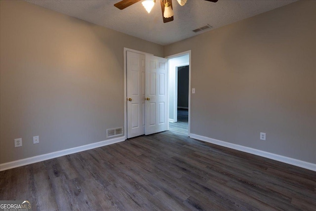 spare room with ceiling fan, dark hardwood / wood-style floors, and a textured ceiling