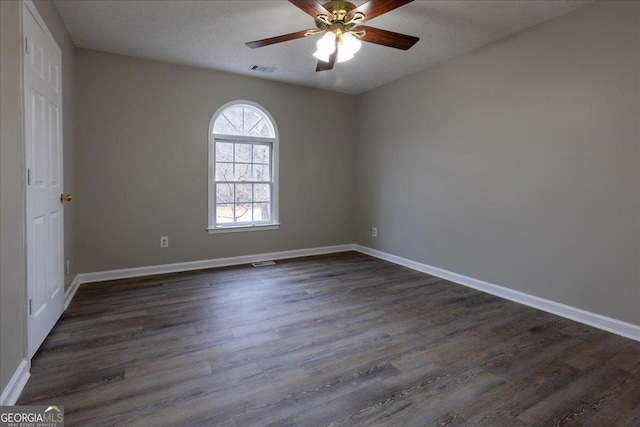 spare room with dark hardwood / wood-style floors, a textured ceiling, and ceiling fan