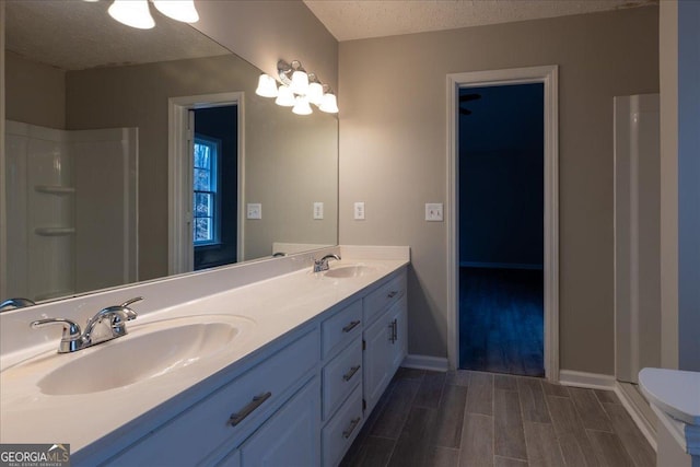 bathroom featuring vanity, toilet, and a textured ceiling