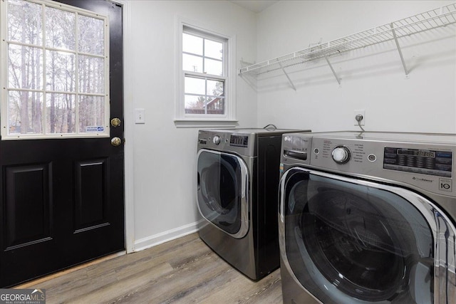 laundry area featuring wood-type flooring and separate washer and dryer