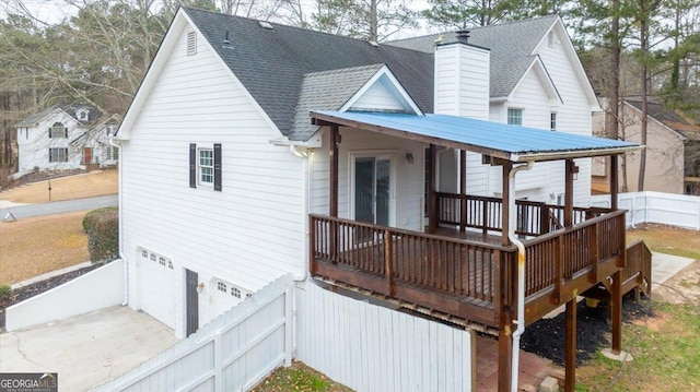 rear view of property featuring a porch and a garage