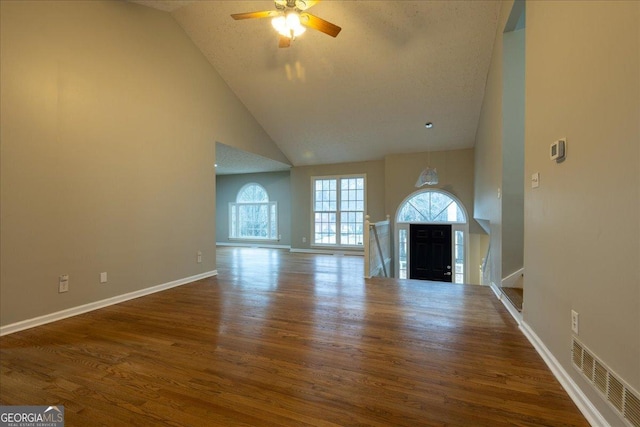 unfurnished living room featuring wood-type flooring, ceiling fan, and high vaulted ceiling