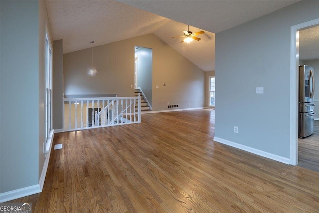 additional living space with ceiling fan, lofted ceiling, hardwood / wood-style floors, and a textured ceiling