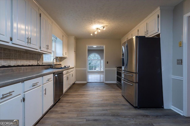 kitchen with sink, dark wood-type flooring, white cabinets, and appliances with stainless steel finishes