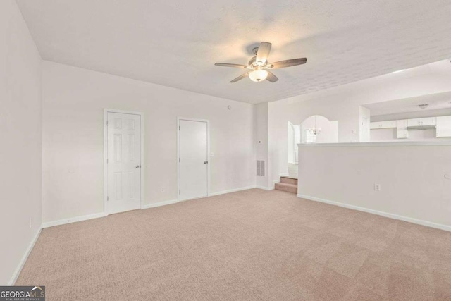 carpeted spare room with ceiling fan and a textured ceiling