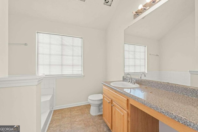 bathroom featuring a tub, vanity, and toilet