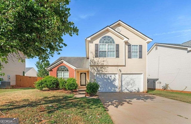 front of property with central air condition unit, a front yard, and a garage