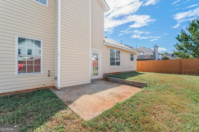 back of house featuring a lawn and a patio