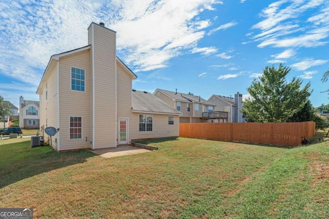 rear view of property with a patio, central AC unit, and a lawn