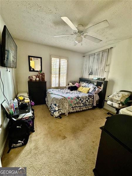 carpeted bedroom with ceiling fan and a textured ceiling