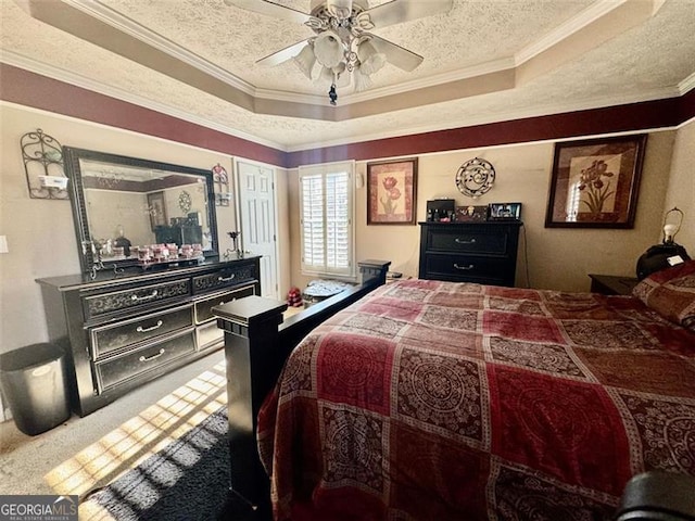 bedroom with a raised ceiling, ceiling fan, ornamental molding, a textured ceiling, and carpet floors