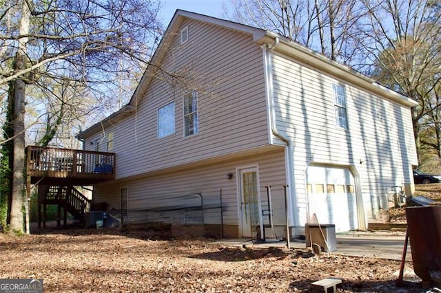 rear view of house with a garage and a deck