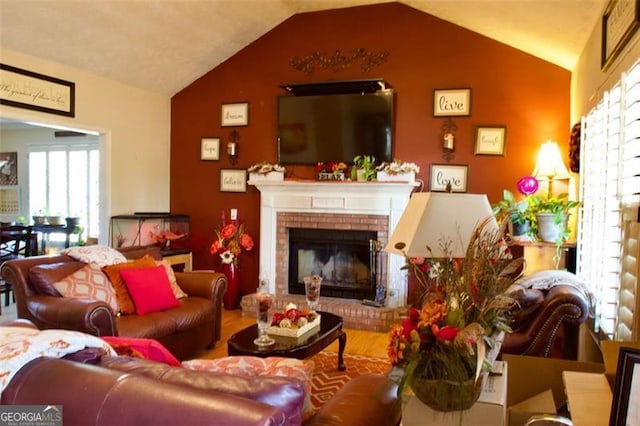 living room featuring a brick fireplace and vaulted ceiling