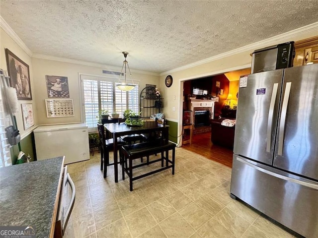 dining area featuring a textured ceiling and crown molding