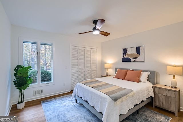 bedroom featuring ceiling fan, dark hardwood / wood-style flooring, and a closet