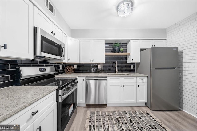 kitchen with white cabinetry, sink, stainless steel appliances, and light wood-type flooring