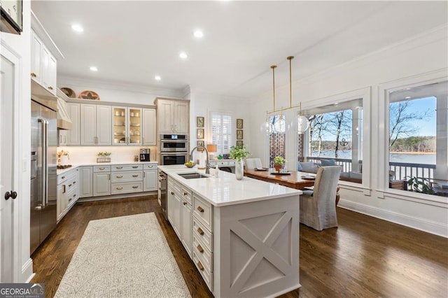 kitchen featuring dark hardwood / wood-style floors, sink, an island with sink, and hanging light fixtures