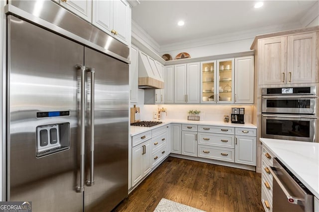 kitchen featuring white cabinets, custom range hood, and appliances with stainless steel finishes