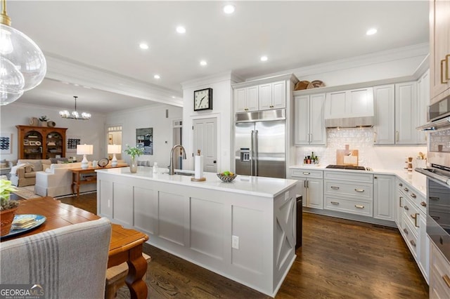 kitchen featuring tasteful backsplash, a center island with sink, white cabinets, and appliances with stainless steel finishes