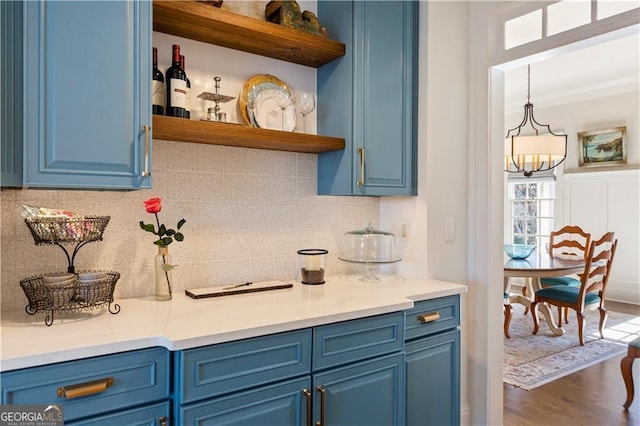 kitchen featuring decorative light fixtures, dark hardwood / wood-style floors, decorative backsplash, and blue cabinetry