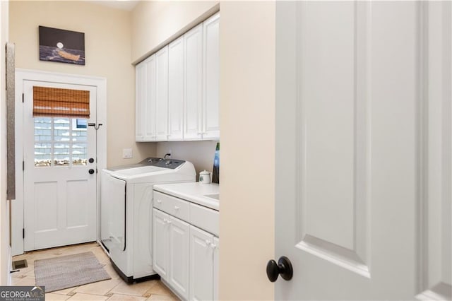 washroom with cabinets, light tile patterned floors, and washing machine and clothes dryer