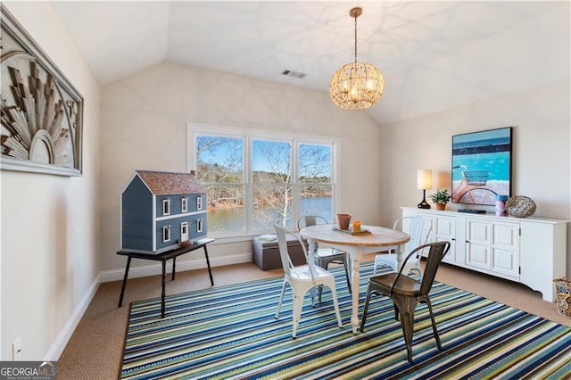 carpeted dining space featuring a chandelier and vaulted ceiling