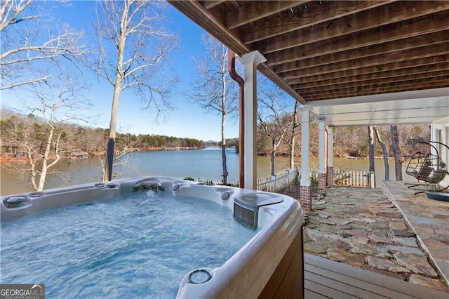 dock area with a water view and a hot tub