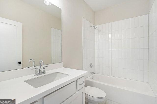 full bathroom with vanity, tiled shower / bath, and toilet