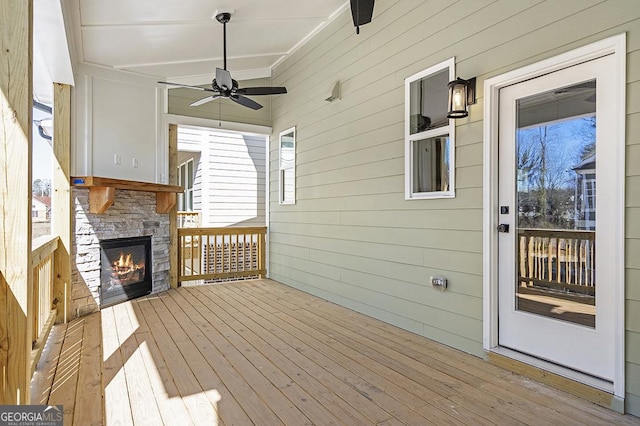 wooden terrace with ceiling fan and a fireplace