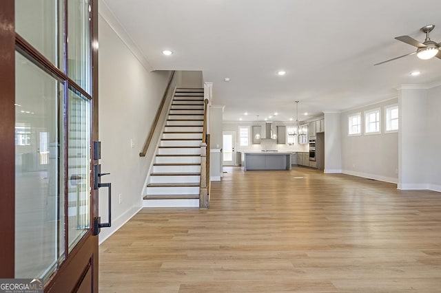 unfurnished living room featuring crown molding and light hardwood / wood-style flooring