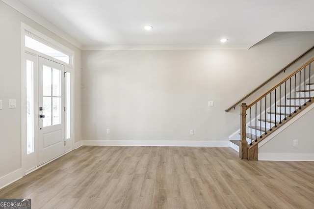 foyer featuring light wood-type flooring and ornamental molding