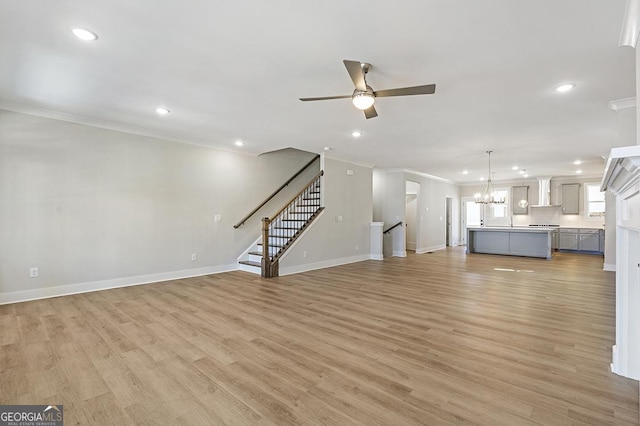 unfurnished living room with ceiling fan with notable chandelier, light hardwood / wood-style flooring, and ornamental molding