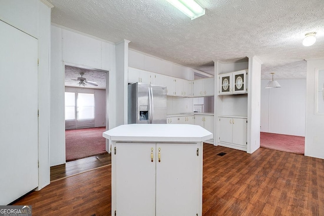 kitchen featuring white cabinets, stainless steel fridge, dark hardwood / wood-style flooring, and pendant lighting