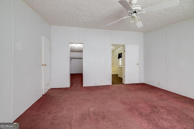 unfurnished bedroom with ceiling fan, a closet, a textured ceiling, and dark carpet