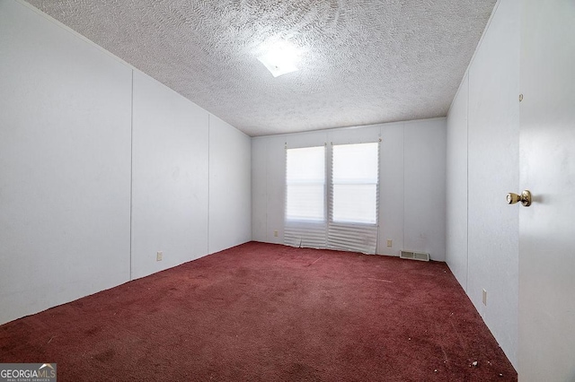 carpeted spare room with a textured ceiling