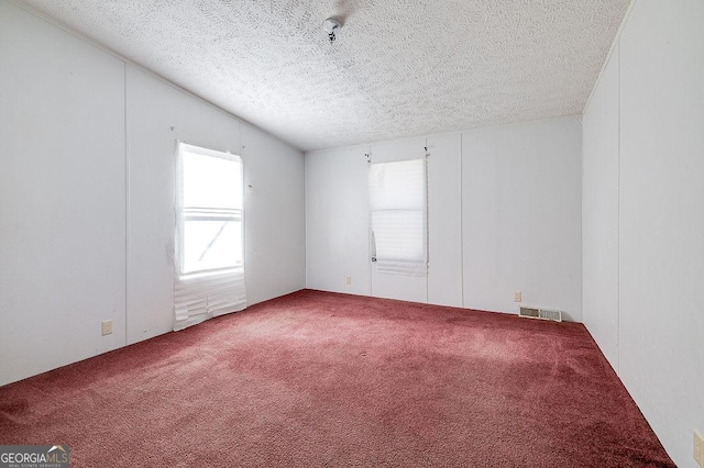 unfurnished room featuring a textured ceiling and carpet flooring