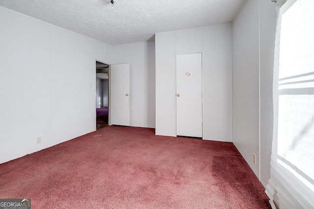 unfurnished bedroom featuring a textured ceiling and carpet flooring