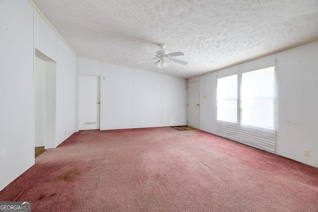 carpeted spare room with a textured ceiling and ceiling fan