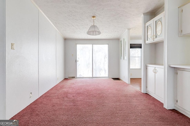 carpeted spare room with a textured ceiling and ornamental molding