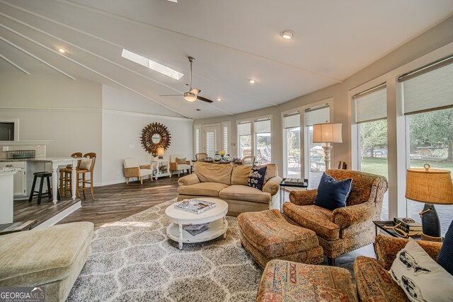 living room with ceiling fan, wood-type flooring, and vaulted ceiling