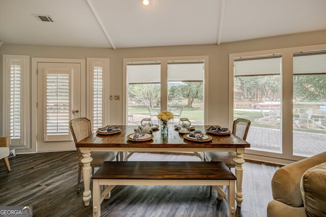 dining space featuring dark wood-type flooring and lofted ceiling