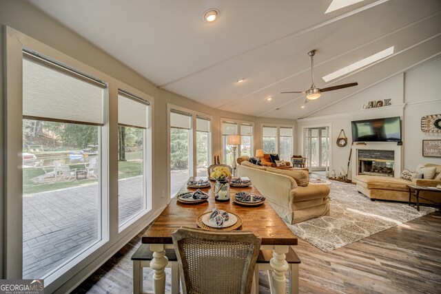 sunroom / solarium featuring ceiling fan and vaulted ceiling with skylight